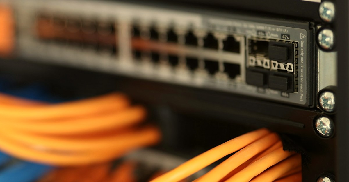 Patch cables terminated into a network switch inside a comms cabinet