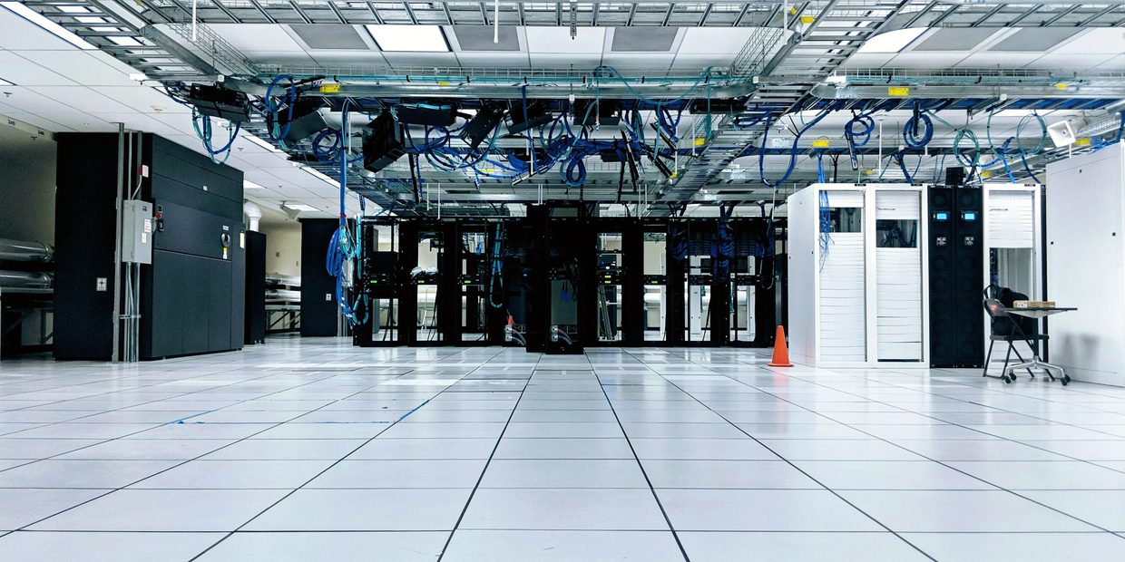 Colocation data hall with overhead cable trays above rows of racks