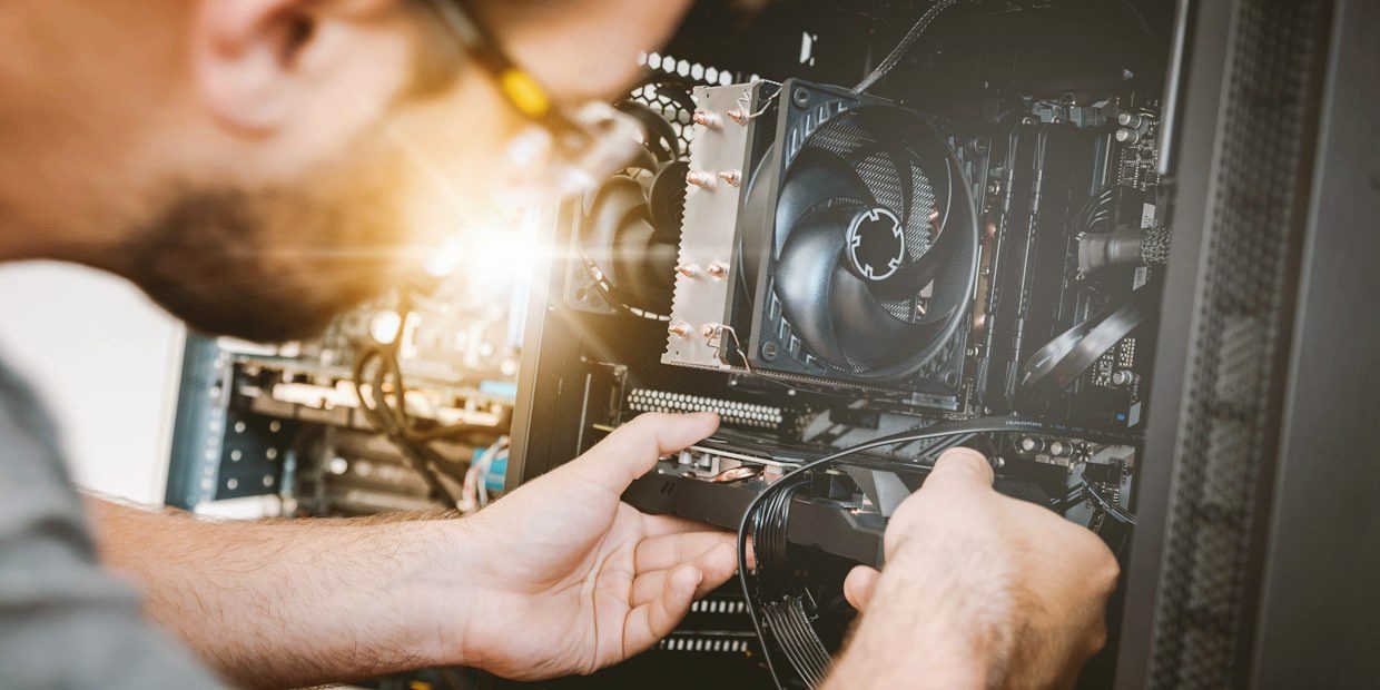 Hands fitting an expansion card inside a desktop computer