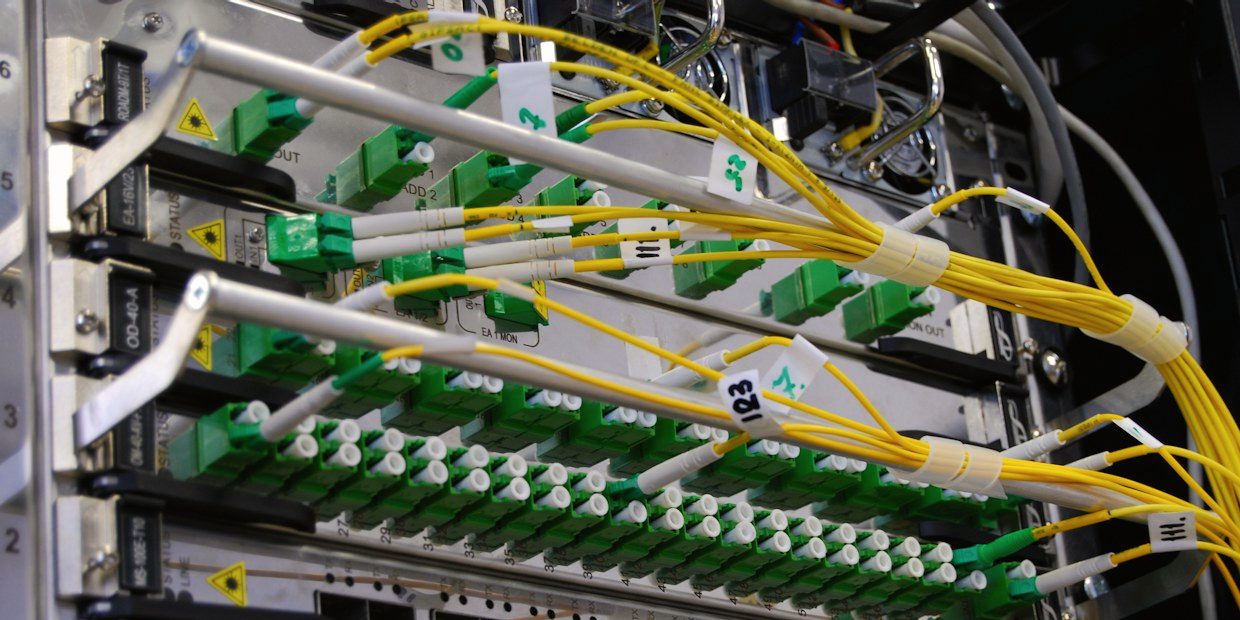 Fiber optic cables patched into a network switch in a rack