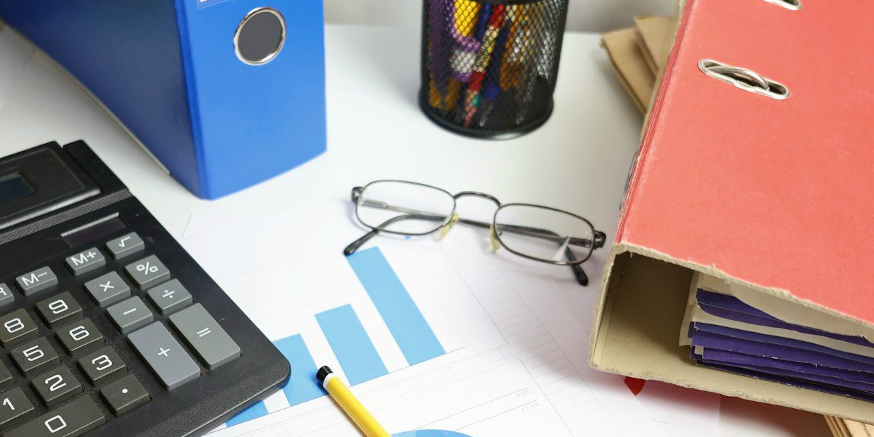 Desk with a calculator, printed charts and ring binders