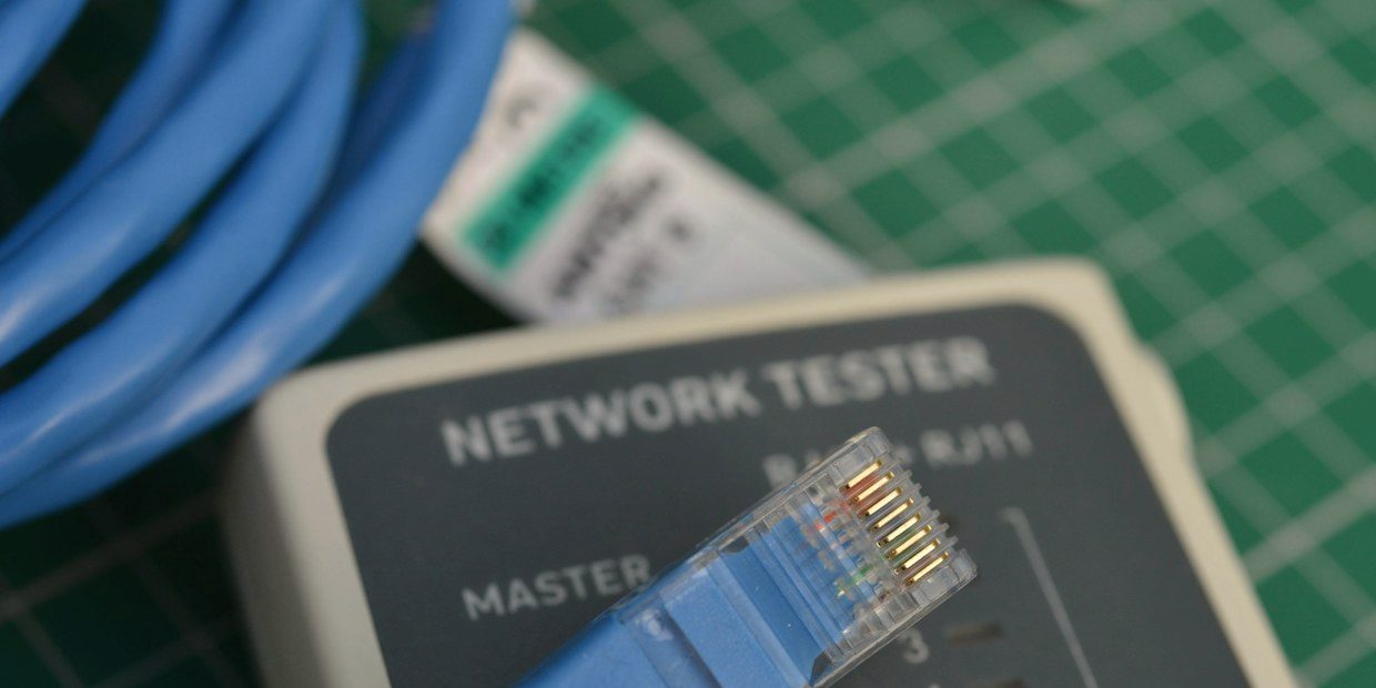 Network cable tester with an RJ45 lead on a workbench